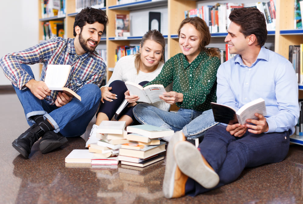 Students reading textbooks in public library