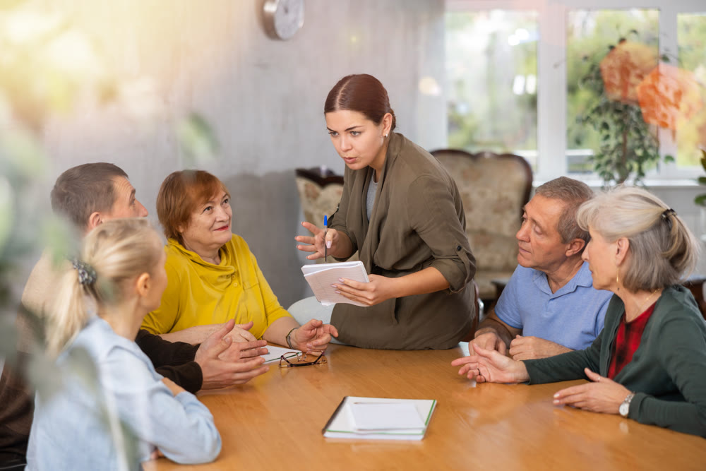 Young female teacher explaining subject to mature students