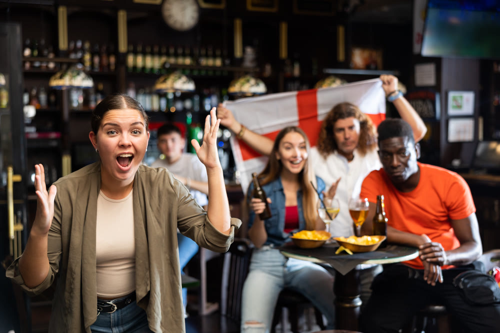 Female England sports fan supporting football team in pub