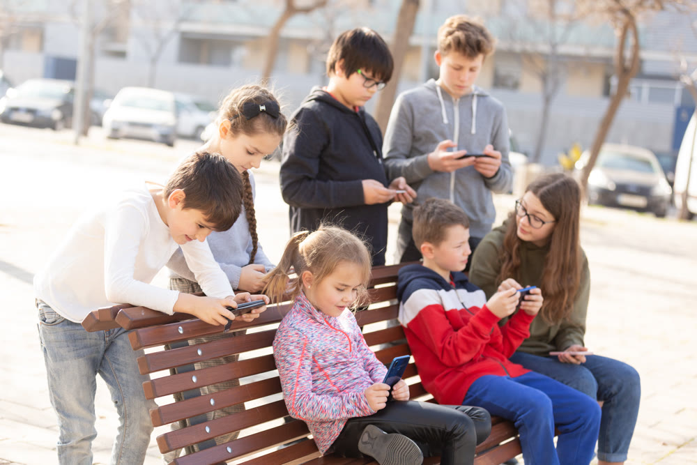 Children addicted in their phones outdoors