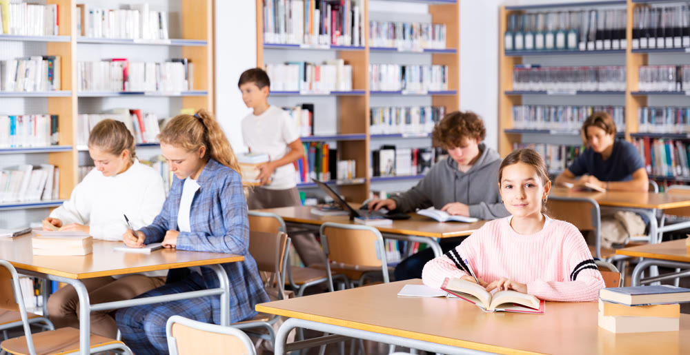 Ten-year-old schoolgirl takes notes in an exercise book of the necessary material