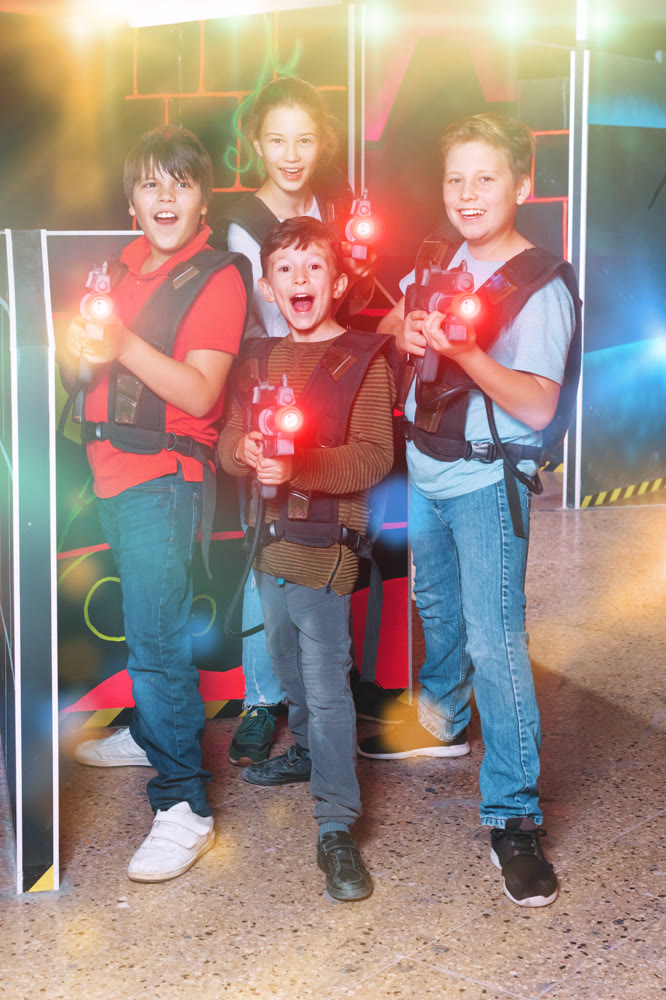 Group portrait of happy teenagers with laser guns having fun on