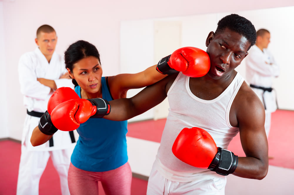 Boxing training between man and woman in sports club