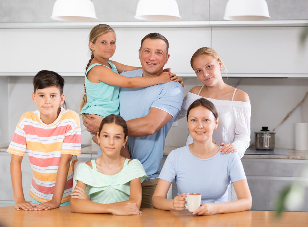 Happy family with four children sitting at table at home