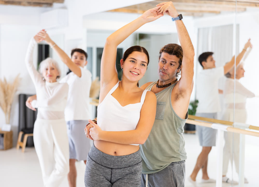 Young woman and adult man dancing as couple