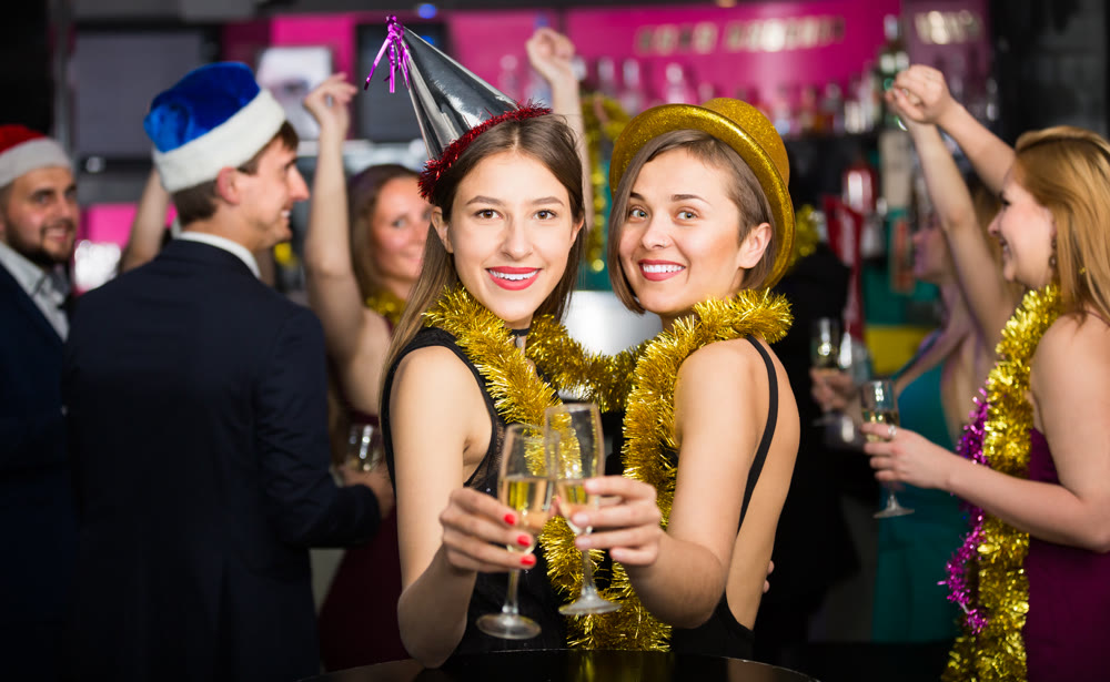 Portrait of smiling females and males in caps and garlands
