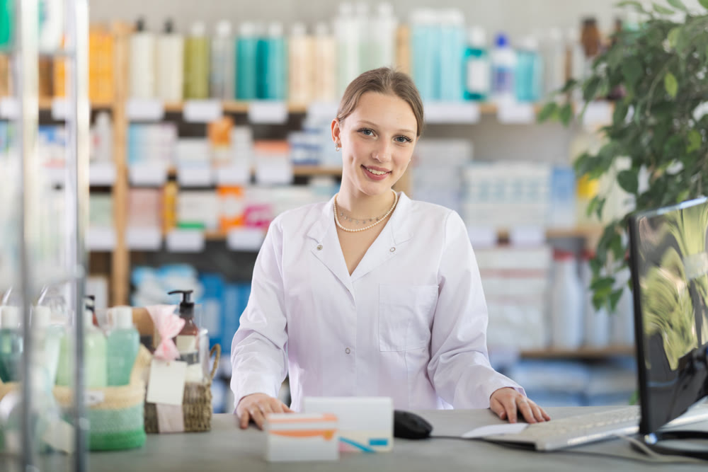 Female pharmacist standing near counter in pharmacy