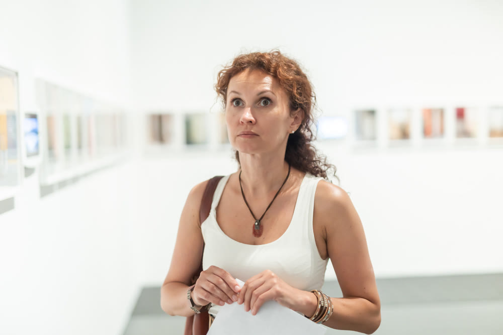 Woman observing photographs on display in photo gallery