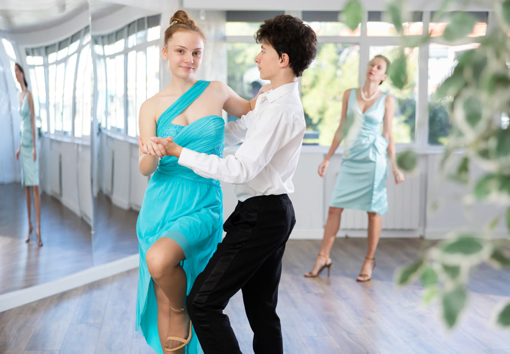 Pair dances - girl and boy in festive attire dance waltz in studio
