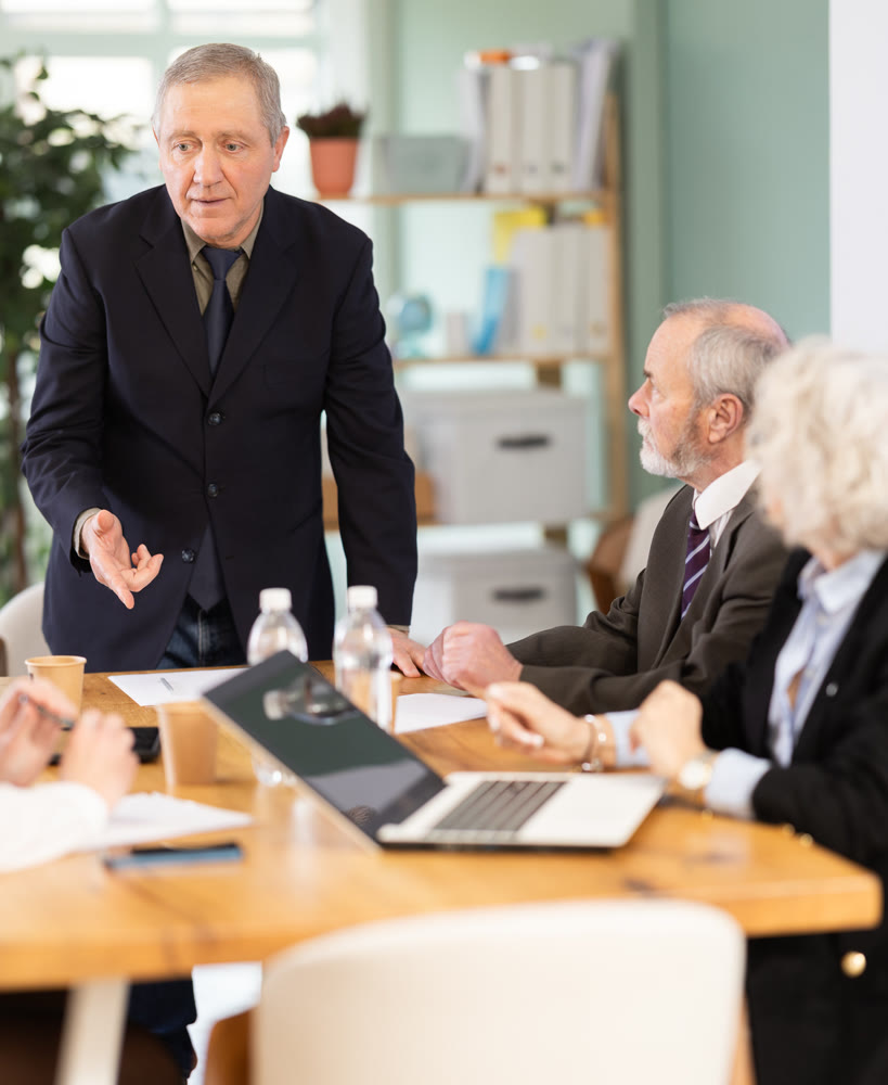Male leader, trainer talking to group of people, brainstorming, discussing ideas in auditory