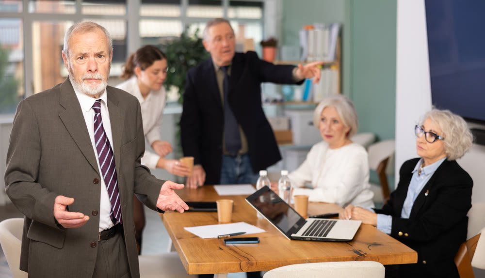 Confused elderly man in office during meeting