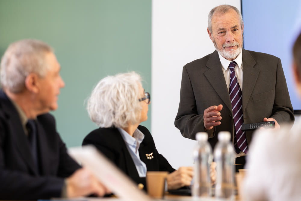 Elderly man presenting with remote control