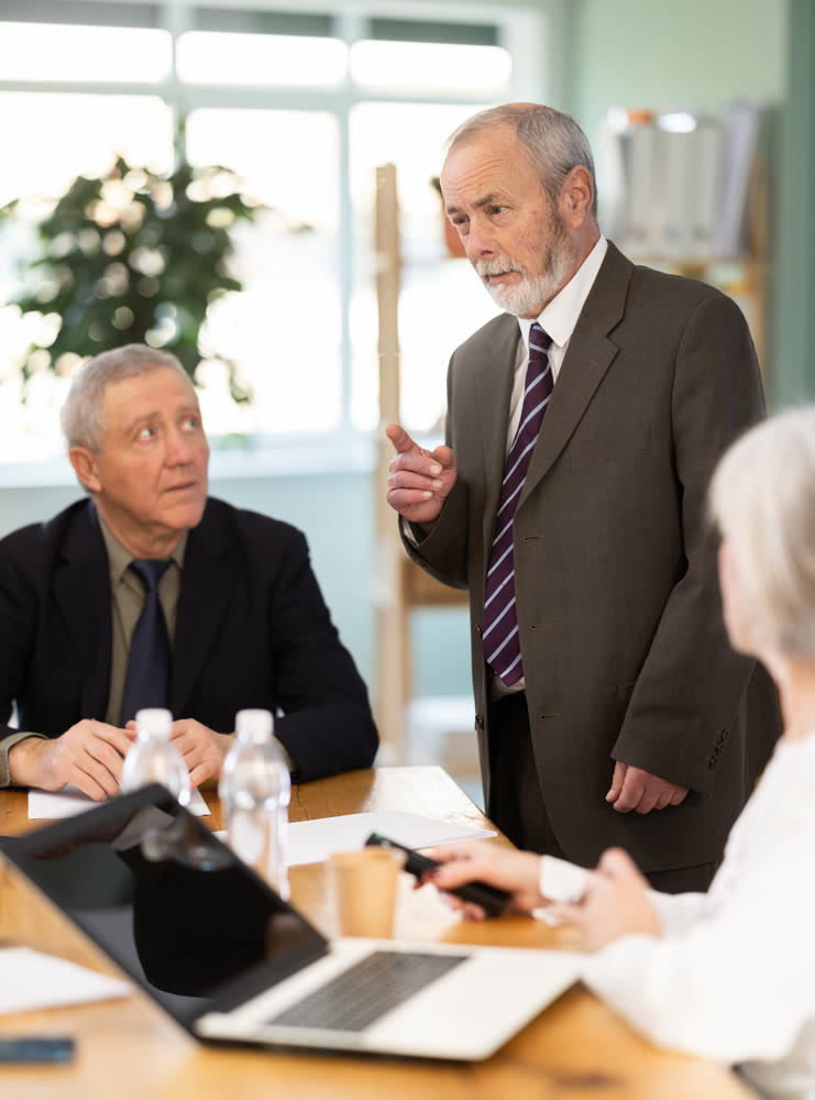 Male leader, trainer talking to group of people, brainstorming, discussing ideas in auditory