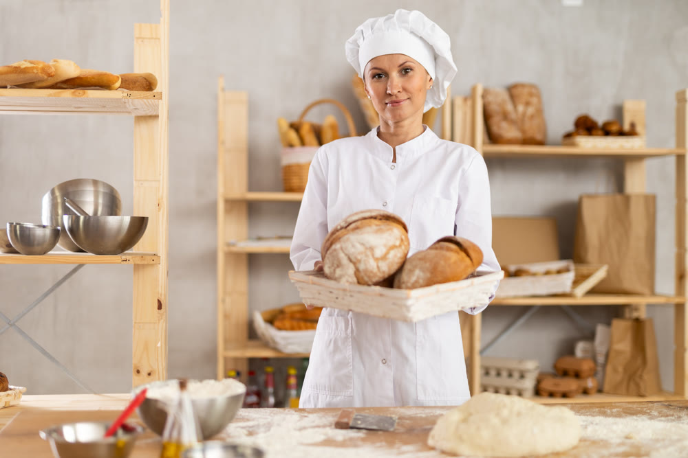 Adult woman with homemade bread in bakery