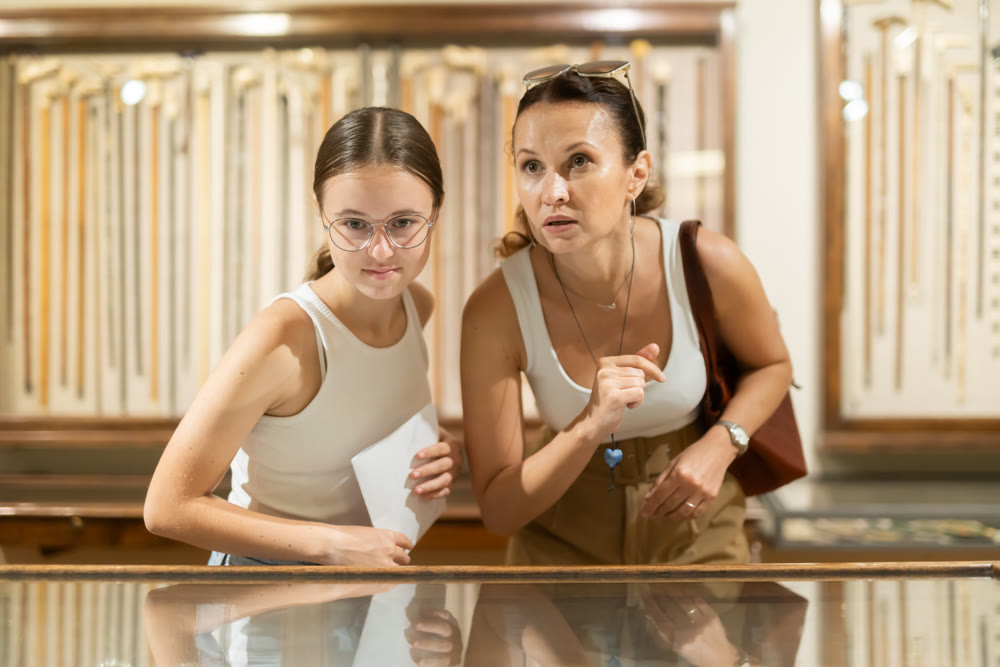 Woman and teenage girl looking at exhibit in museum display