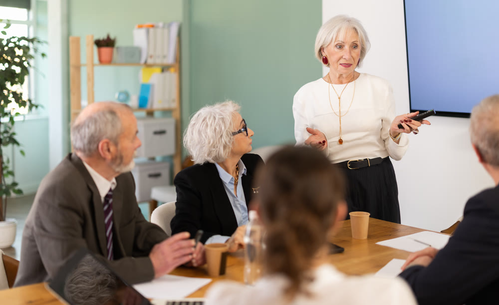 Female leader, trainer talking to group of people, brainstorming, discussing ideas in auditory
