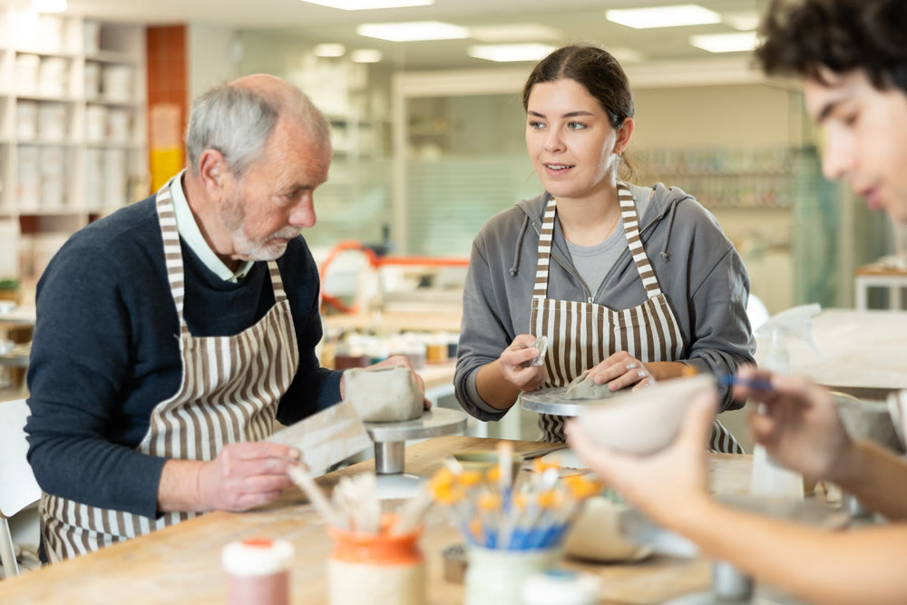 Young woman and man and elderly man crafting ceramics