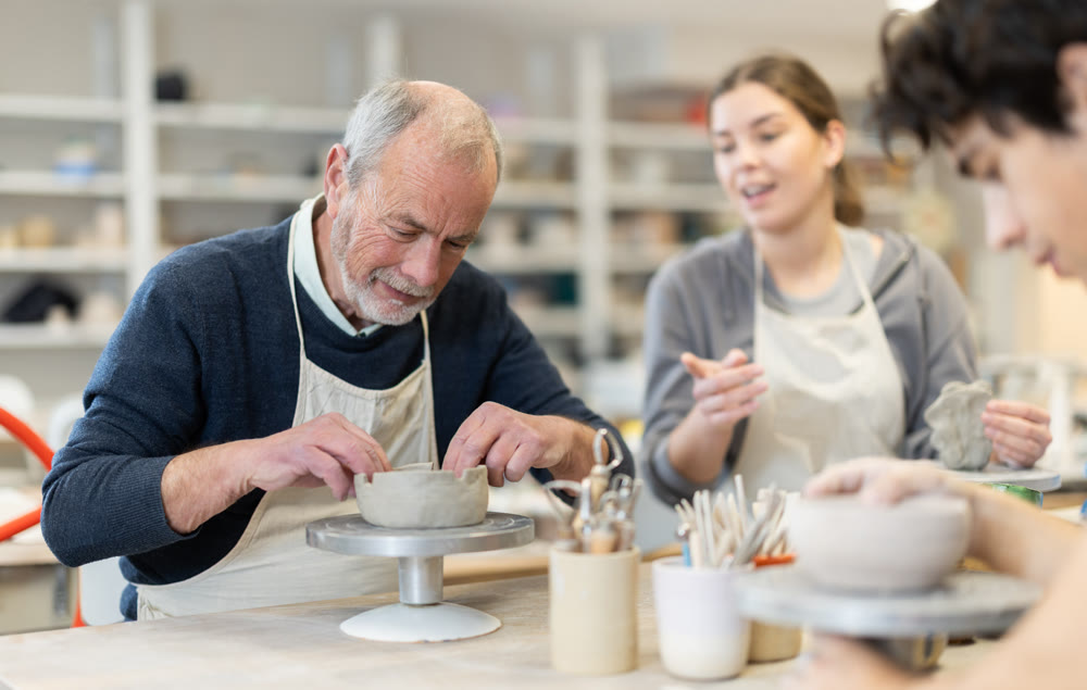 Young woman and man and elderly man crafting ceramics