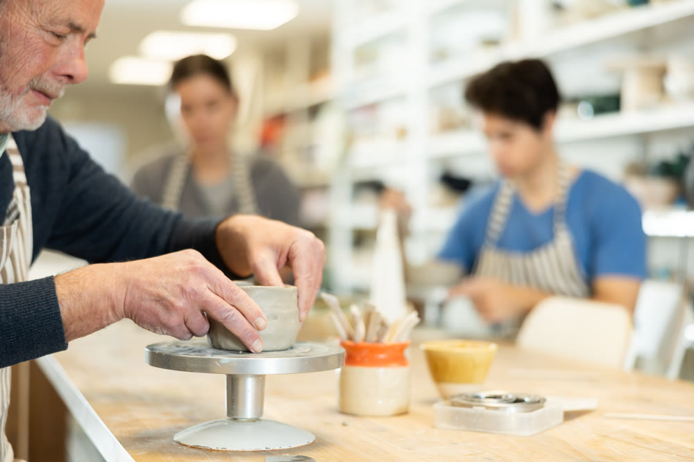 Close-up of elderly man's hands sculpting ceramic piece