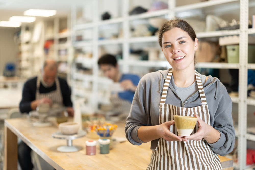 Young woman holding finished ceramic piece