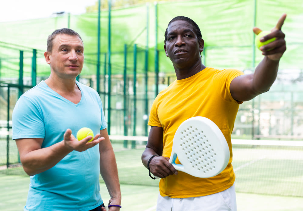 Men talking after padel match outdoors