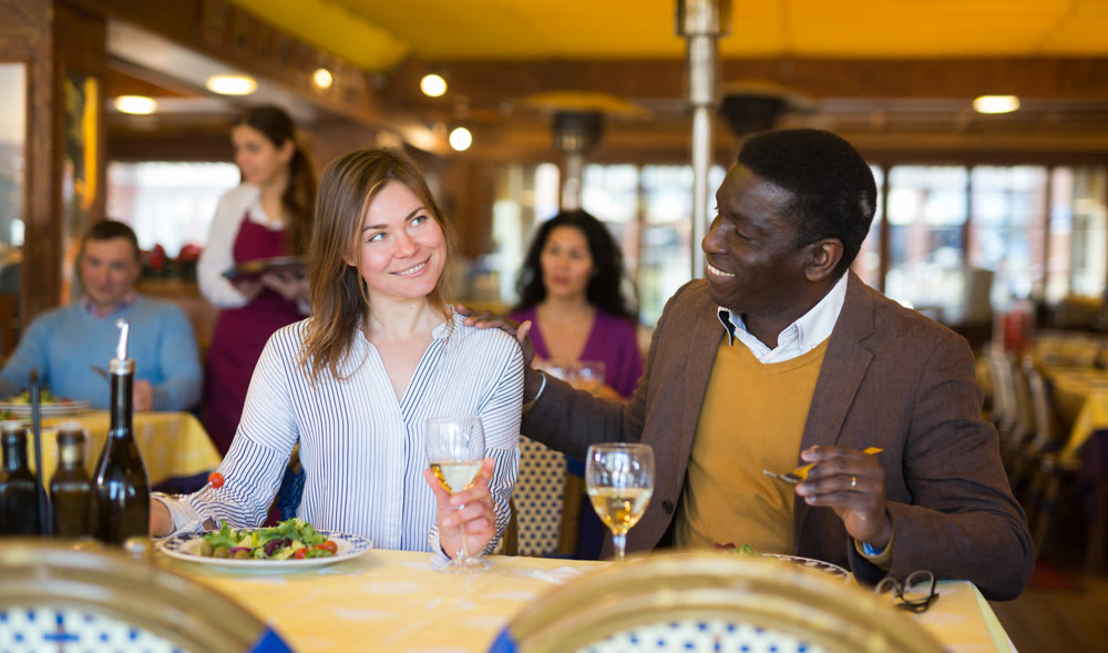 Man and woman chatting while having dinner in restaurant