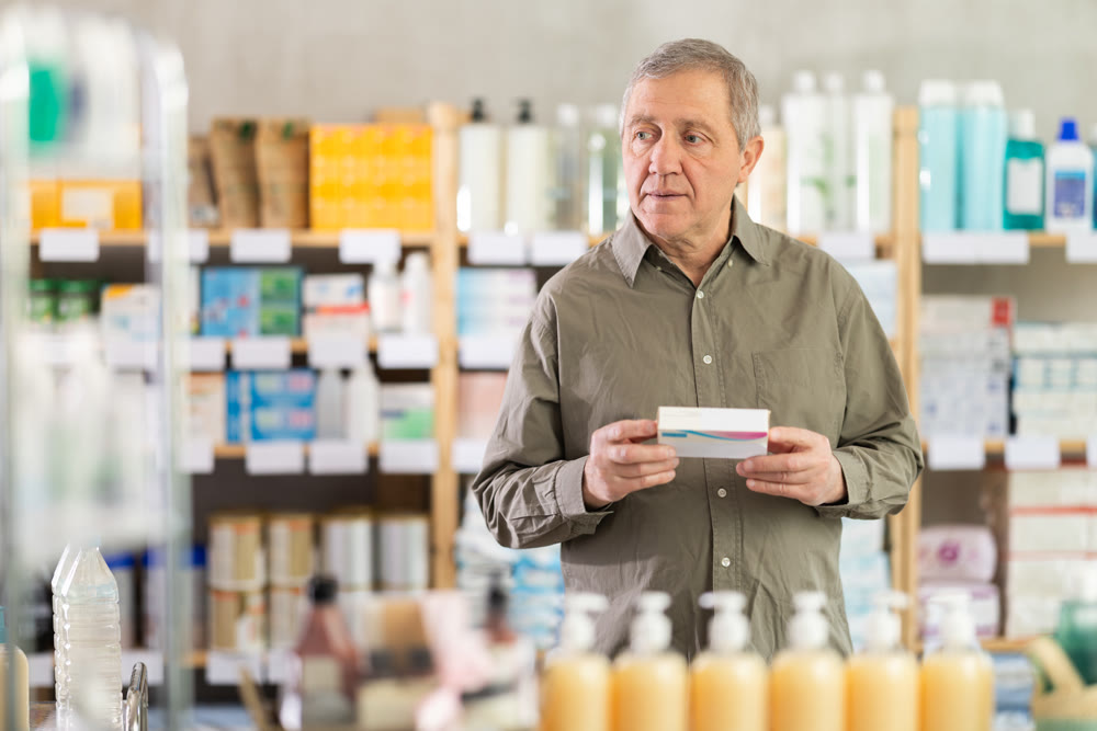 Elderly man in a pharmacy chooses pills