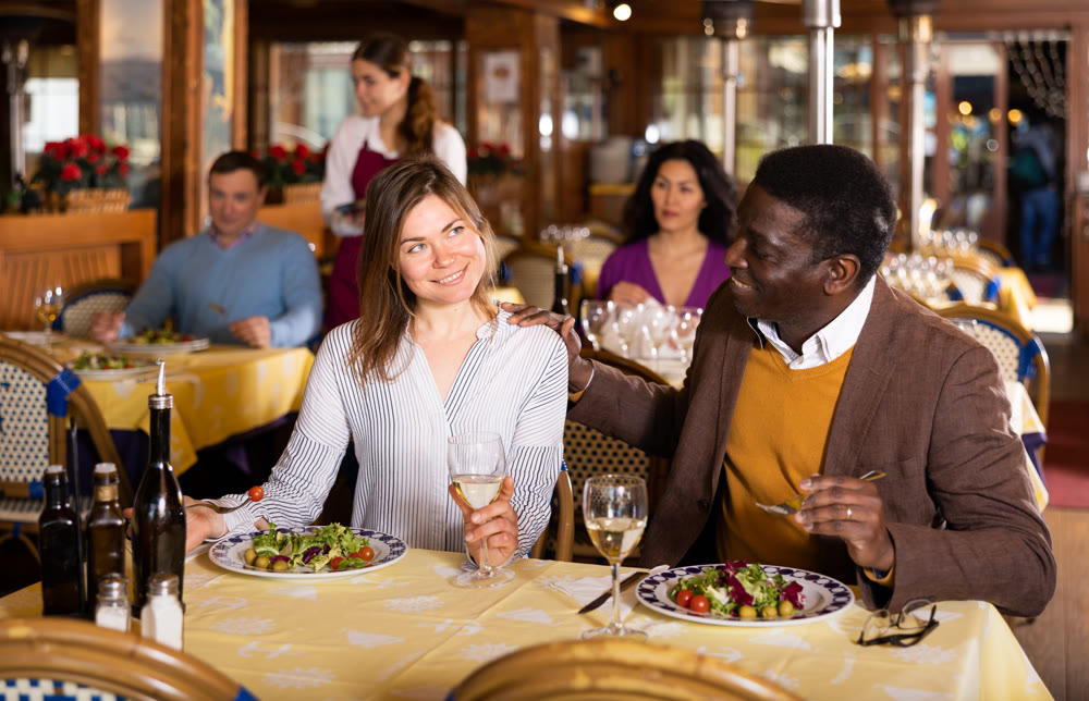 Man and woman chatting while having dinner in restaurant