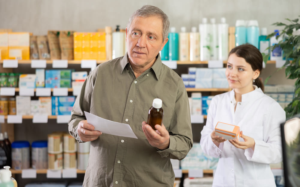 Man choosing pills with help from pharmacist