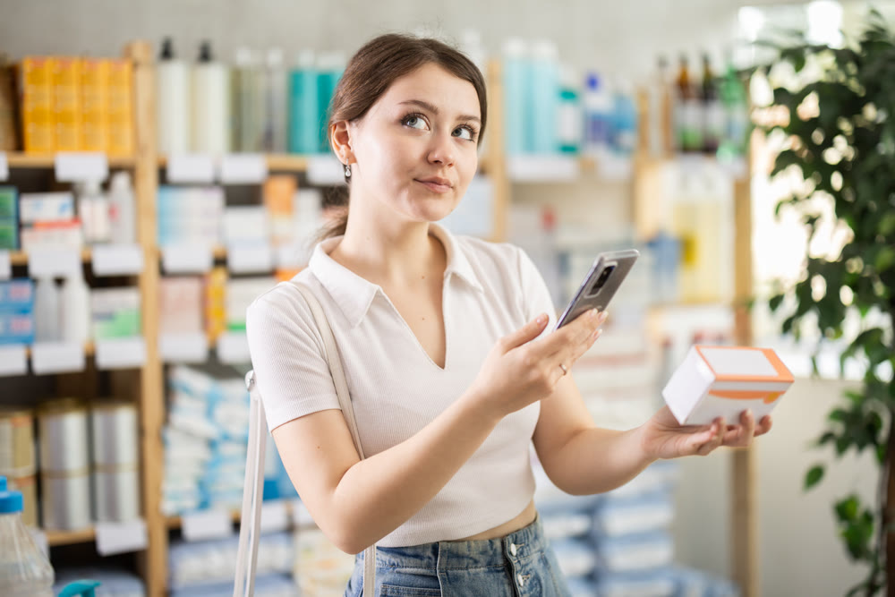 Young woman scanning paracetamol barcode on her phone