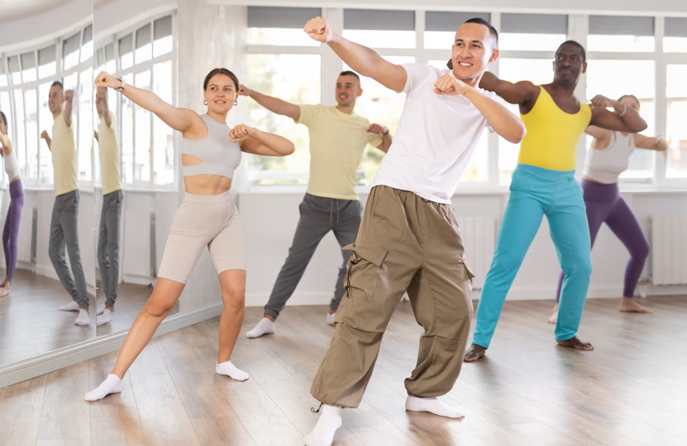Guy practices kicking and punching in process of self-defense at group lesson