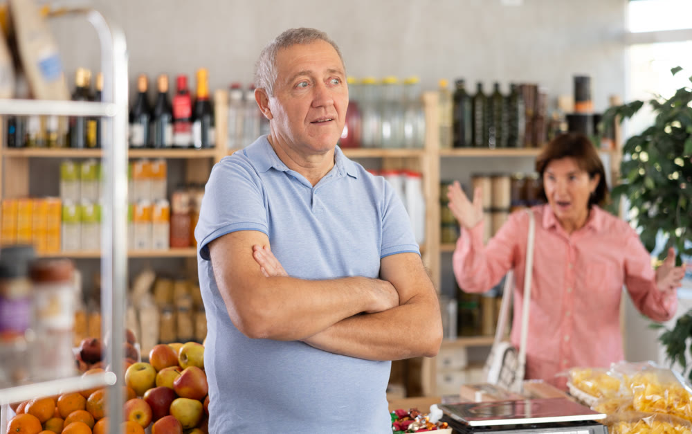 Family quarrel between elderly husband and wife in grocery supermarket. Woman screams at her husband