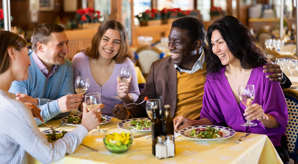 Group of people chatting and laughing in restaurant