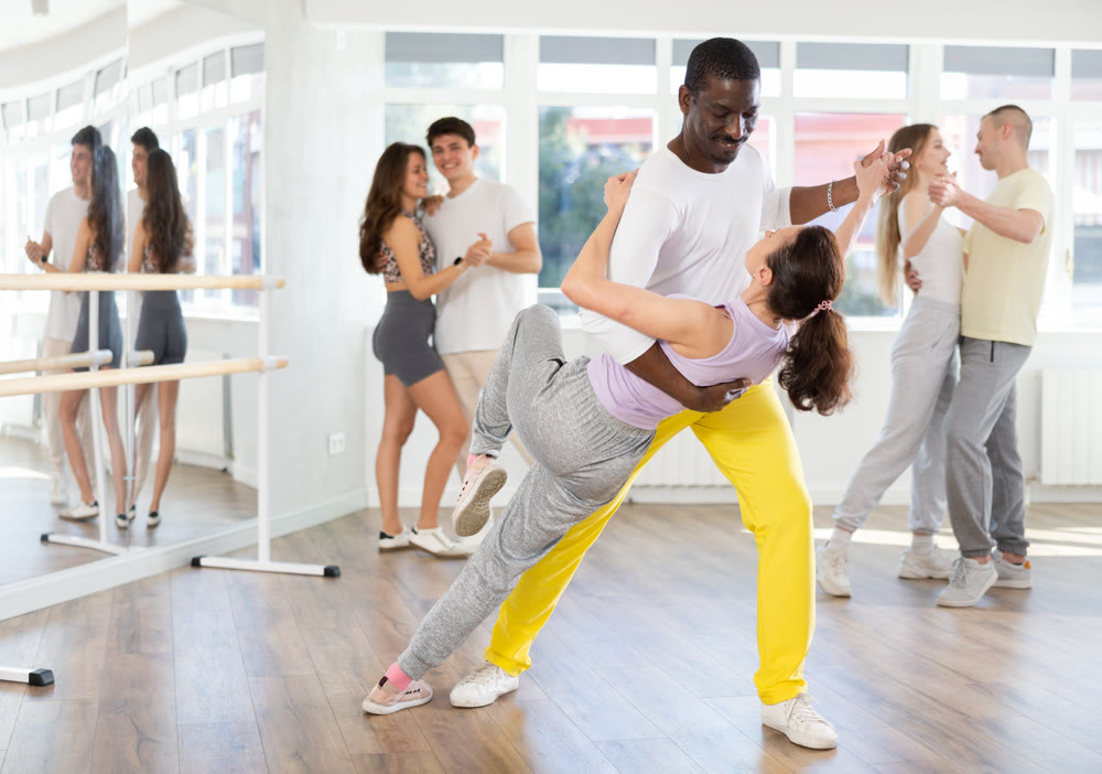 Woman dances incendiary tango with African man partner during choreography lesson