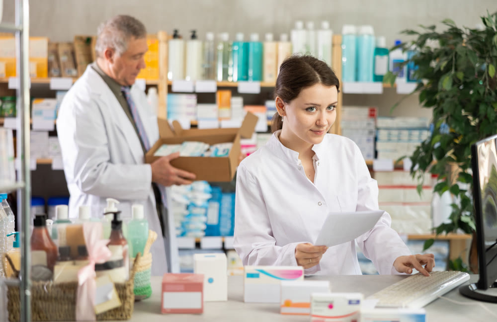 Female pharmacist checking prescription on computer