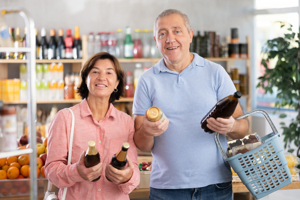 Senior couple hold bottle and choose consider alcohol beer in store