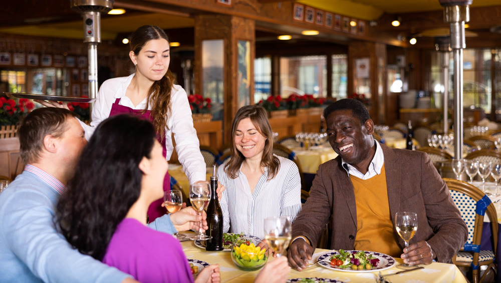 Couple on friendly meeting over dinner with wine in restaurant