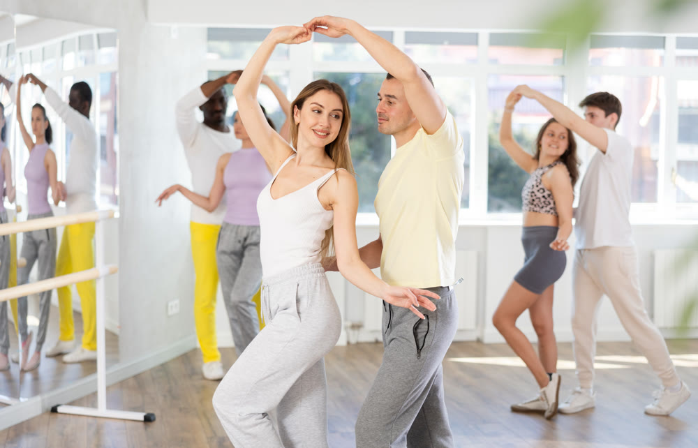Young woman dances incendiary tango with man partner during choreography lesson