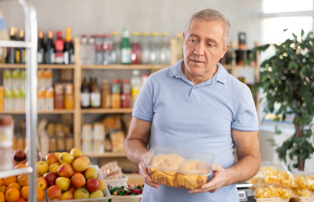 Mature man is choosing chicken in grocery store