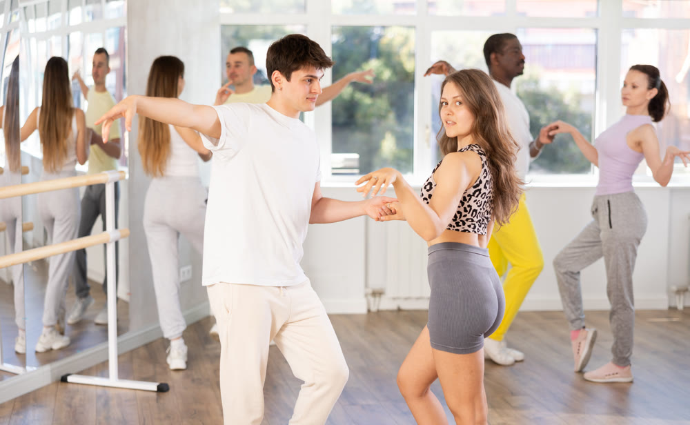 Young couple practicing passionate samba in dance class