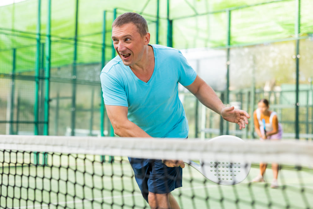 Man training to play tennis on padel court outdoor