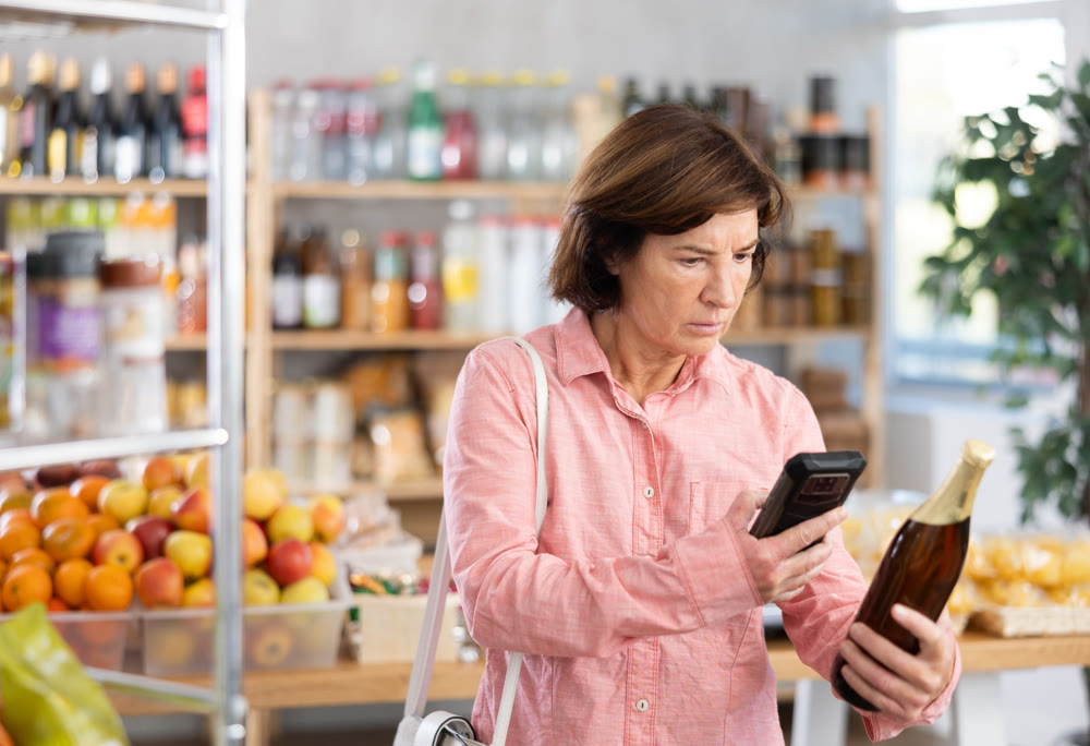 Female buyer scans QR code on beer label in grocery store