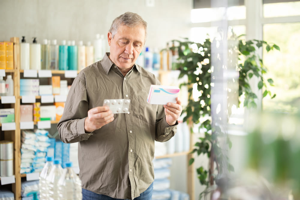 Senior man buys pills at pharmacy