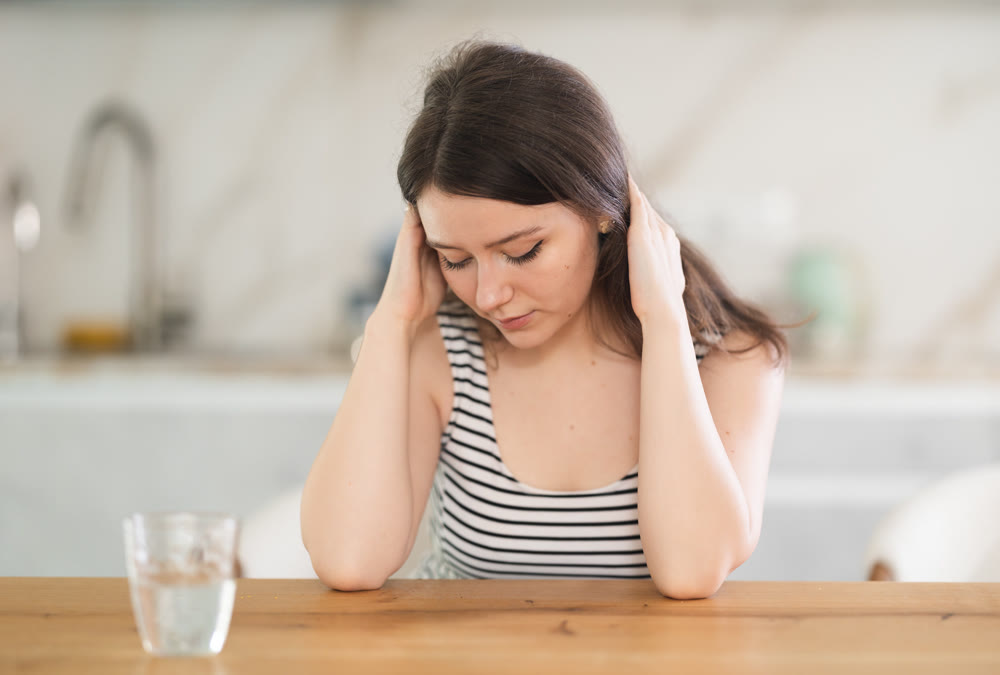 Thoughtful young woman sitting at table