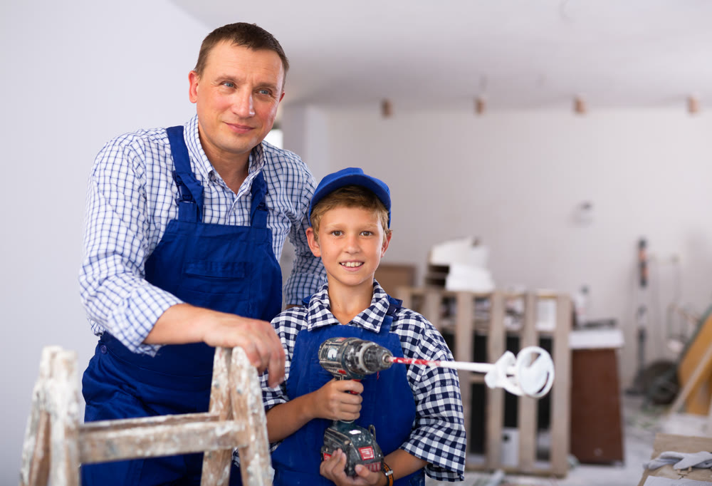 Boy with father holding renovating home tools