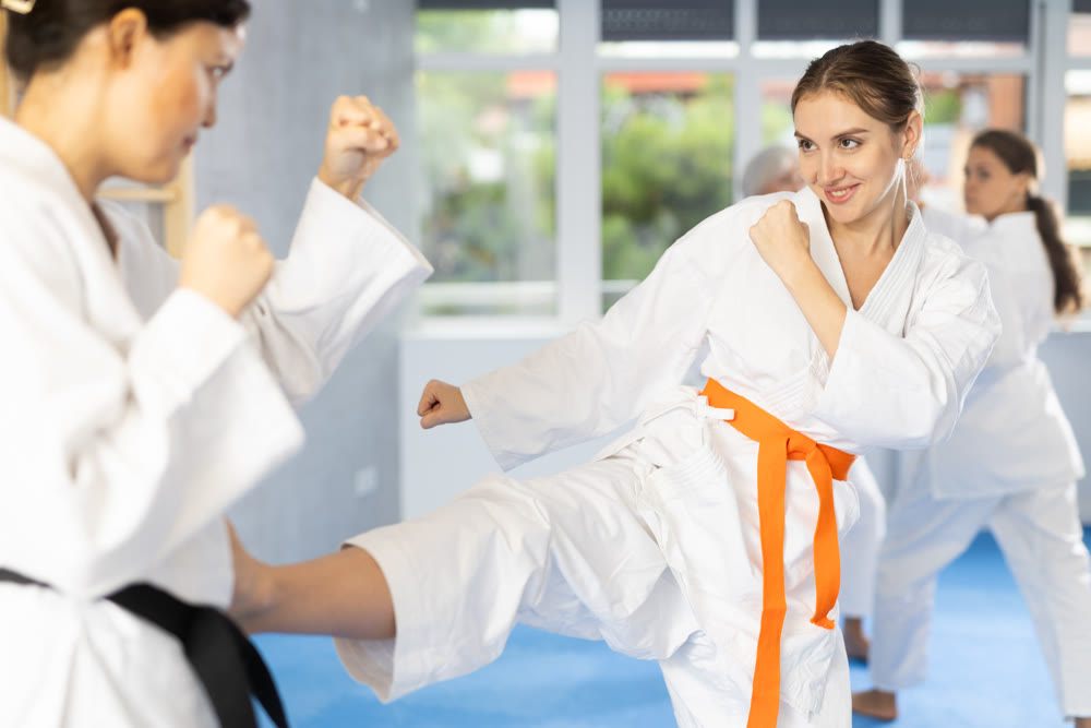 Group of women of different ages practicing punches during karate classes in gym