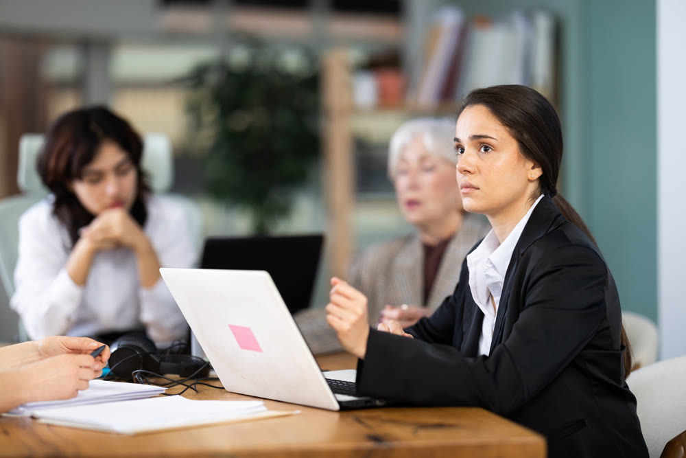Young girl looking sad and tired while using computer in office