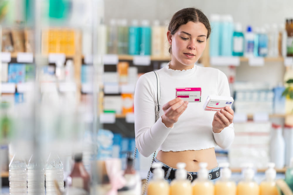 Female buyer buys paracetamol medicine at pharmacy