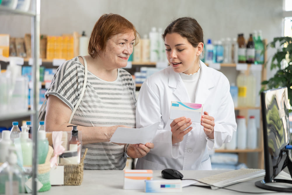 Woman pharmacist looking for prescription on computer for buyer