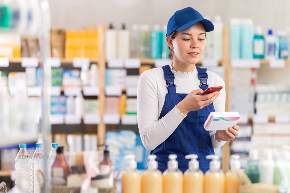 Young woman worker scanning qr code of pills